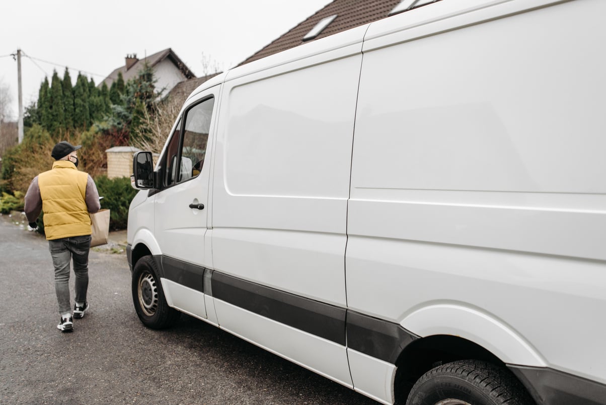 Man Walking Beside a Delivery Van